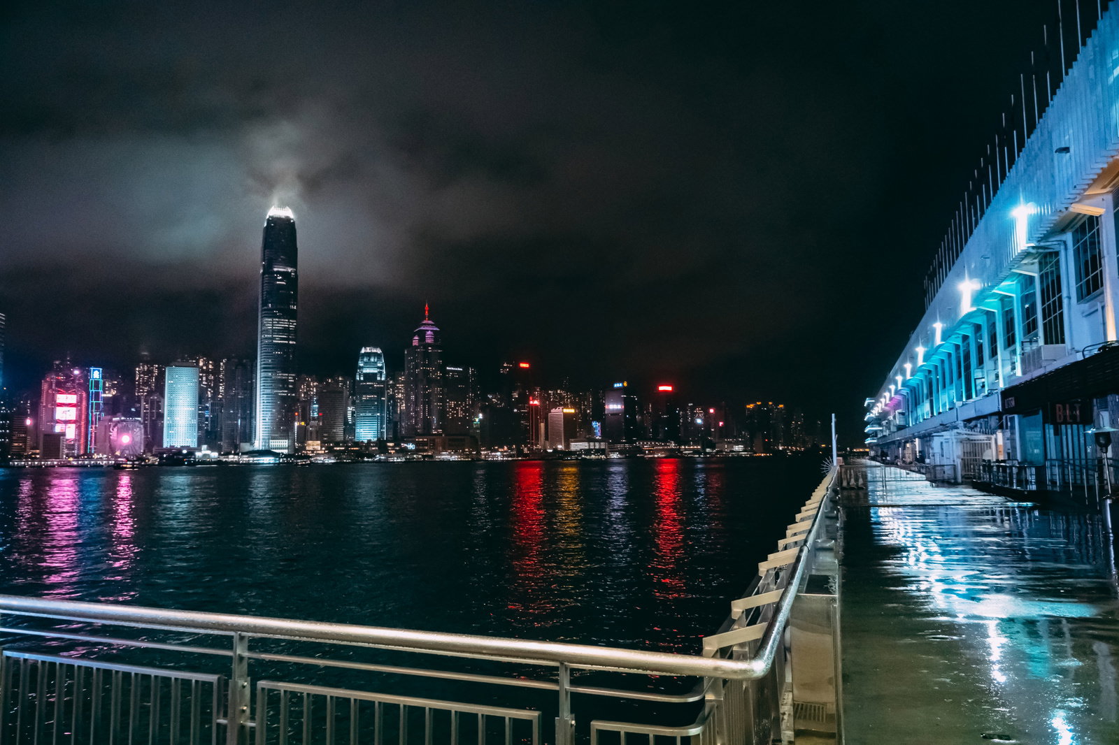 雨の夜にハーバーシティから見た香港の夜景、高層ビルの光が水面に反射