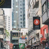 仮想通貨や令和など色々な店の看板が目立つ香港の繁華街の写真