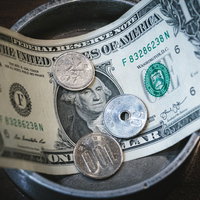 1ドル札と151円の硬貨を並べた為替レートの写真