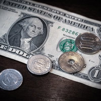 1ドル=152円の為替相場を示す1ドル札と硬貨の写真