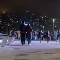 尖沙咀東部海濱公園のプロムナードを歩く香港の人々の写真
