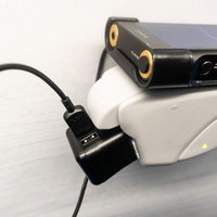 新幹線の座席でウォークマンをUSBケーブルで充電の写真