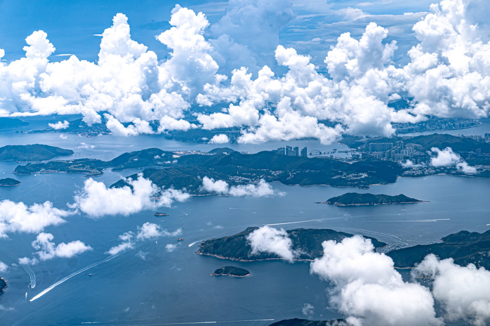 香港の海に浮かぶ島々と上空に広がる白い雲の航空写真