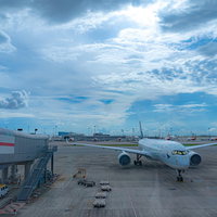 香港国際空港のターミナルから見える駐機中の飛行機と青空の写真