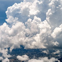 湿度が高く分厚い雲が覆いかぶさる香港のビル群の写真