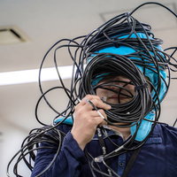 10本のLANケーブルが絡まってしまったエンジニアの写真