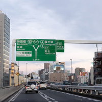 高速道路を走行する車と道路標識の交通風景の写真