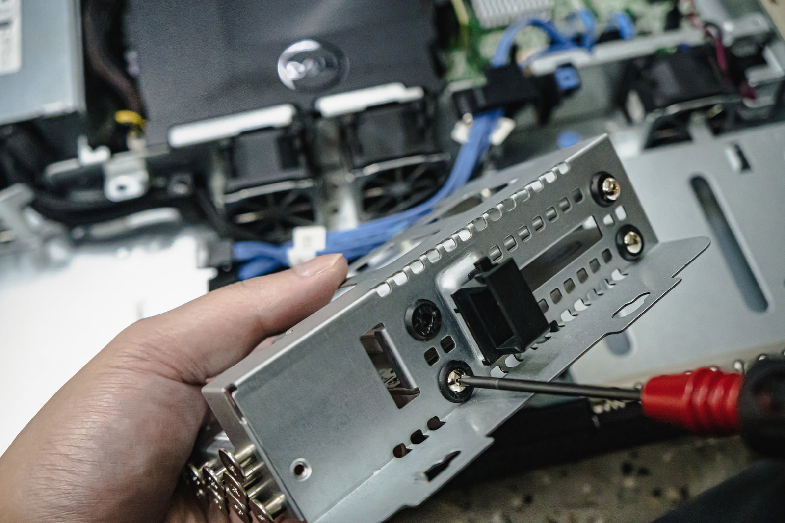 ドライバーを使ってSSDを取り外すエンジニアの手元作業