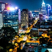 ホーチミンシティの夜景を彩る高層ビル群とネオンの写真
