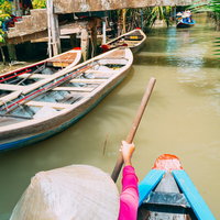 ベトナムの水路で手漕ぎボートを漕いで目的地へ向かう様子の写真