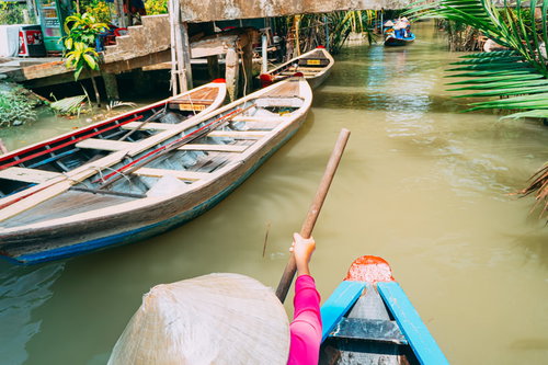 ベトナムの水路で手漕ぎボートを漕いで目的地へ向かう様子