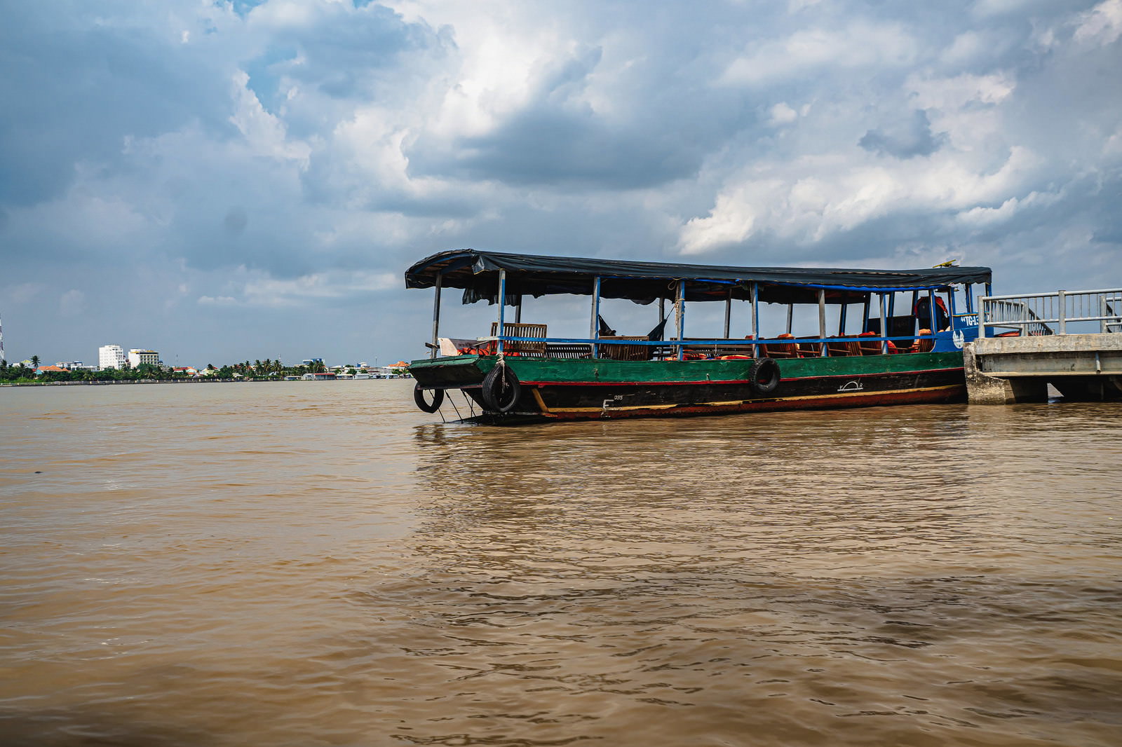 Blue-roofed boats moored at a Mekong River ferry station