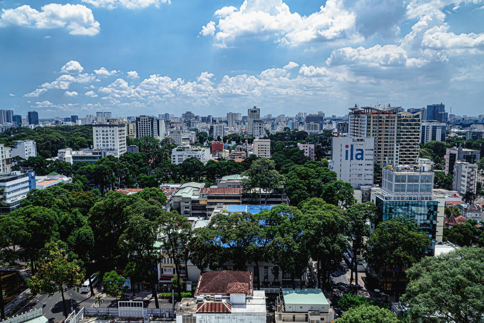 高層ビルと緑豊かな住宅街が広がるホーチミンシティの昼間の街並み