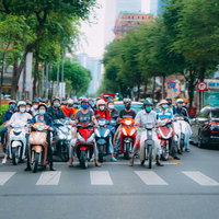 ベトナムの車道で信号待ちをする原チャリ集団の写真