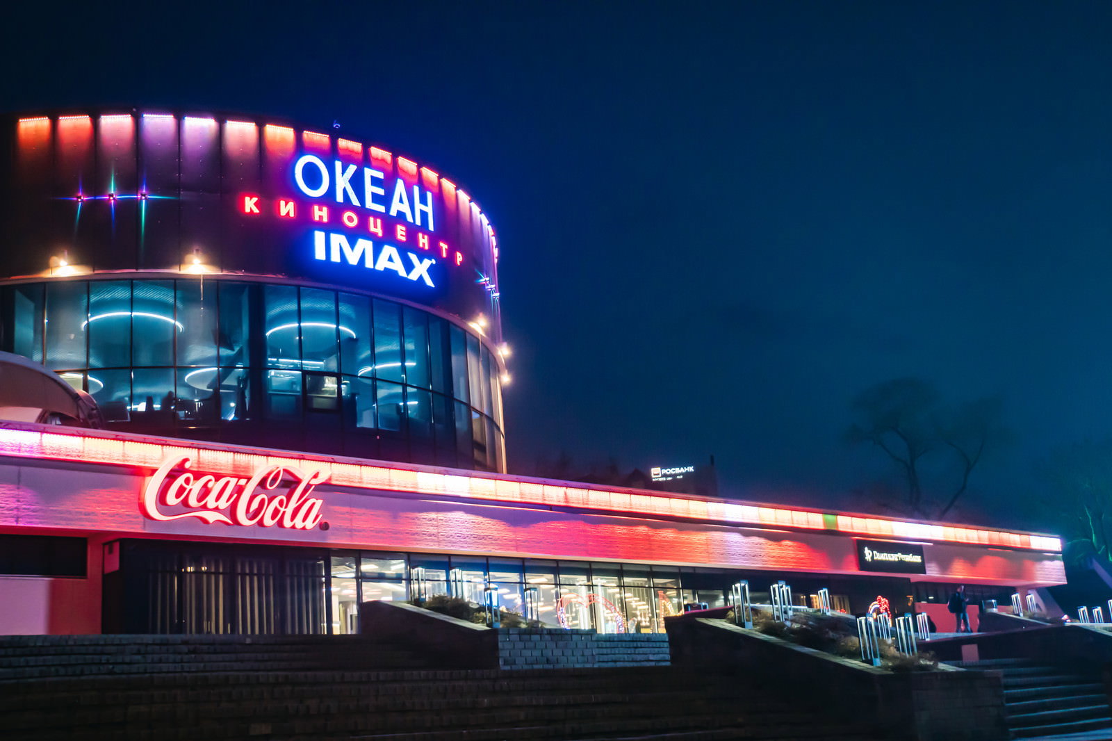 夜のウラジオストクにあるオケアン映画館とネオンサイン