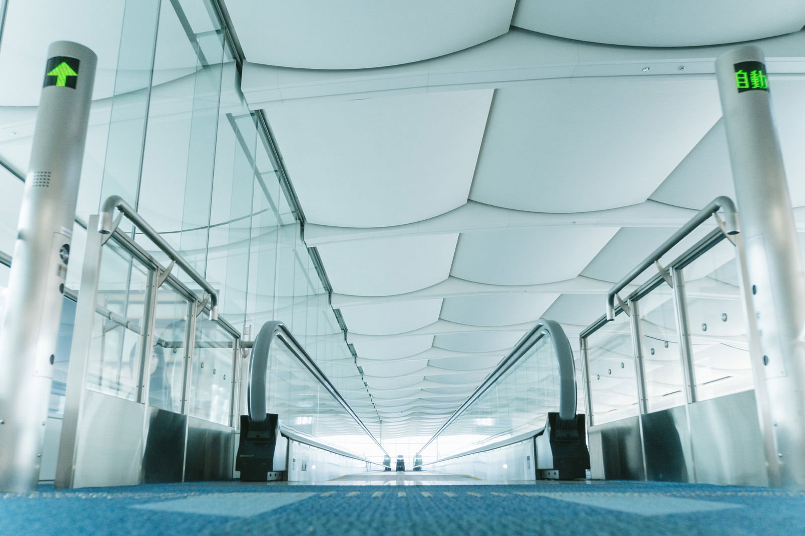 羽田空港の白い動く歩道、シンメトリーな近未来的デザインの通路