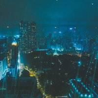 尖沙咀の夜景を雨に濡れたガラス窓越しに見る深夜の都会の写真