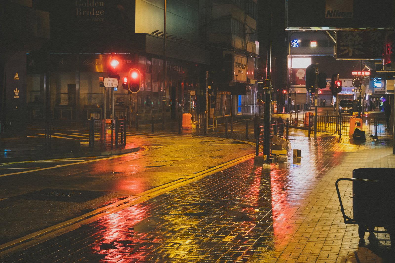 雨に濡れた路面が街灯の光を反射する香港尖沙咀の夜景