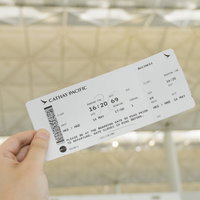 空港のターミナルで搭乗券を手に持つエアポート投稿おじさんの写真