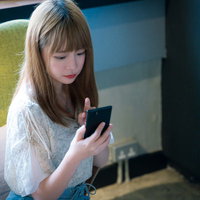 カフェでスマホを見ながらメニューを決める女性の写真