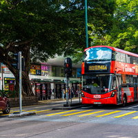 香港の彌敦道（ネイザンロード）で信号待ちをしている赤い2階建てバスの写真