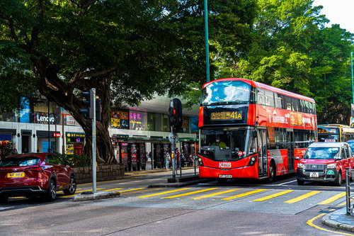 香港の彌敦道（ネイザンロード）で信号待ちをしている赤い2階建てバス