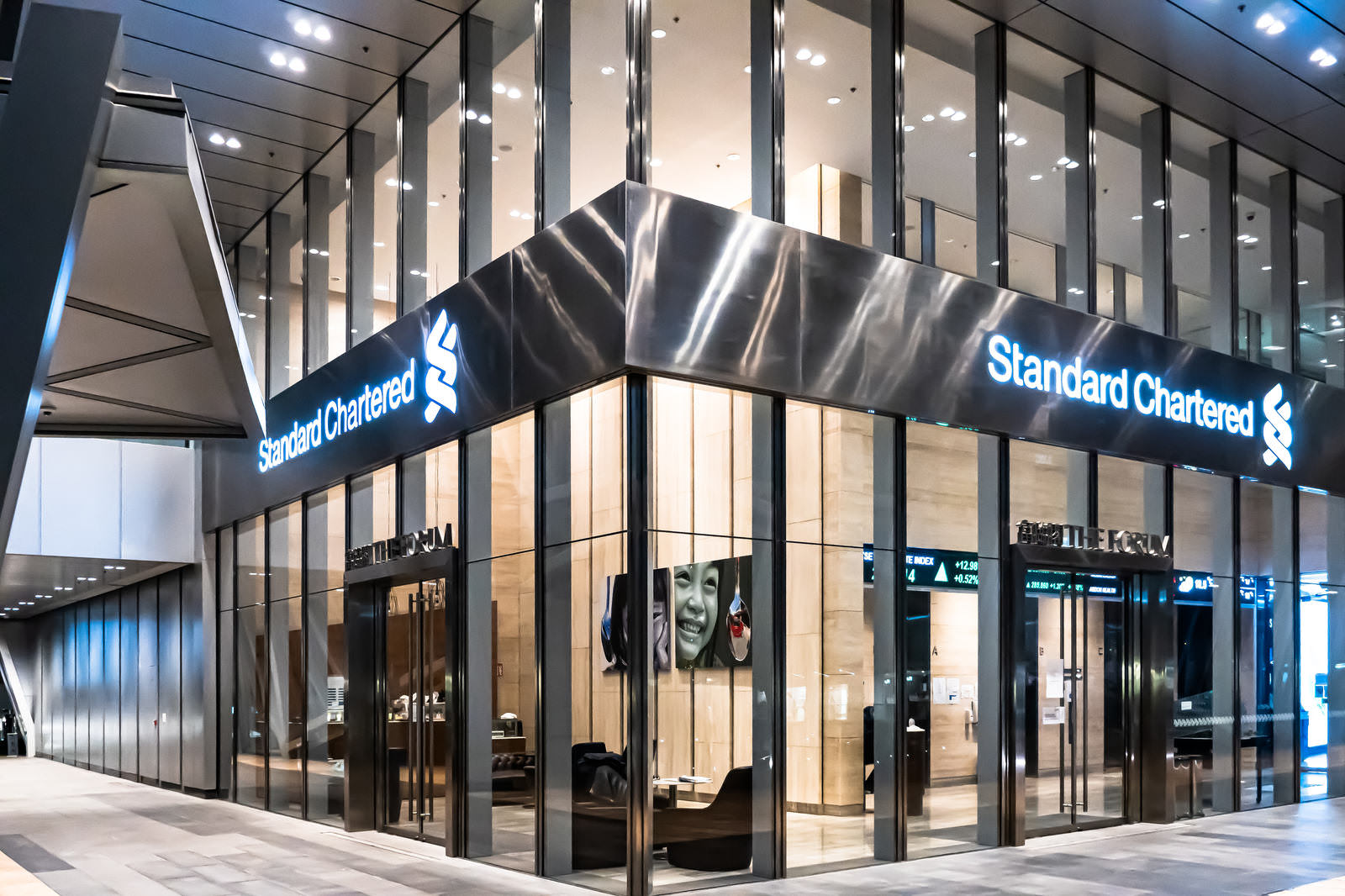 香港中環のスタンダードチャータード銀行店舗、ガラス張りの建物に青い電飾看板