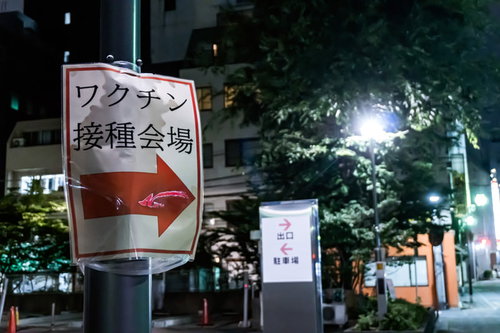 夜間のワクチン接種会場へ案内する矢印看板