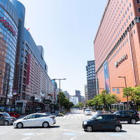 三越と大丸がある福岡天神の交差点、高層ビルと行き交う人々の写真