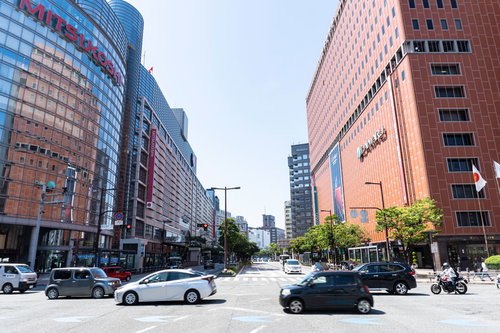 三越と大丸がある福岡天神の交差点、高層ビルと行き交う人々