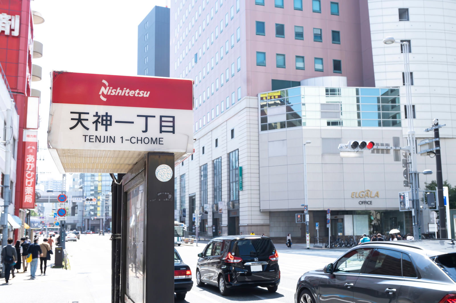 天神一丁目のバス停標識と周辺の都市部の街並み