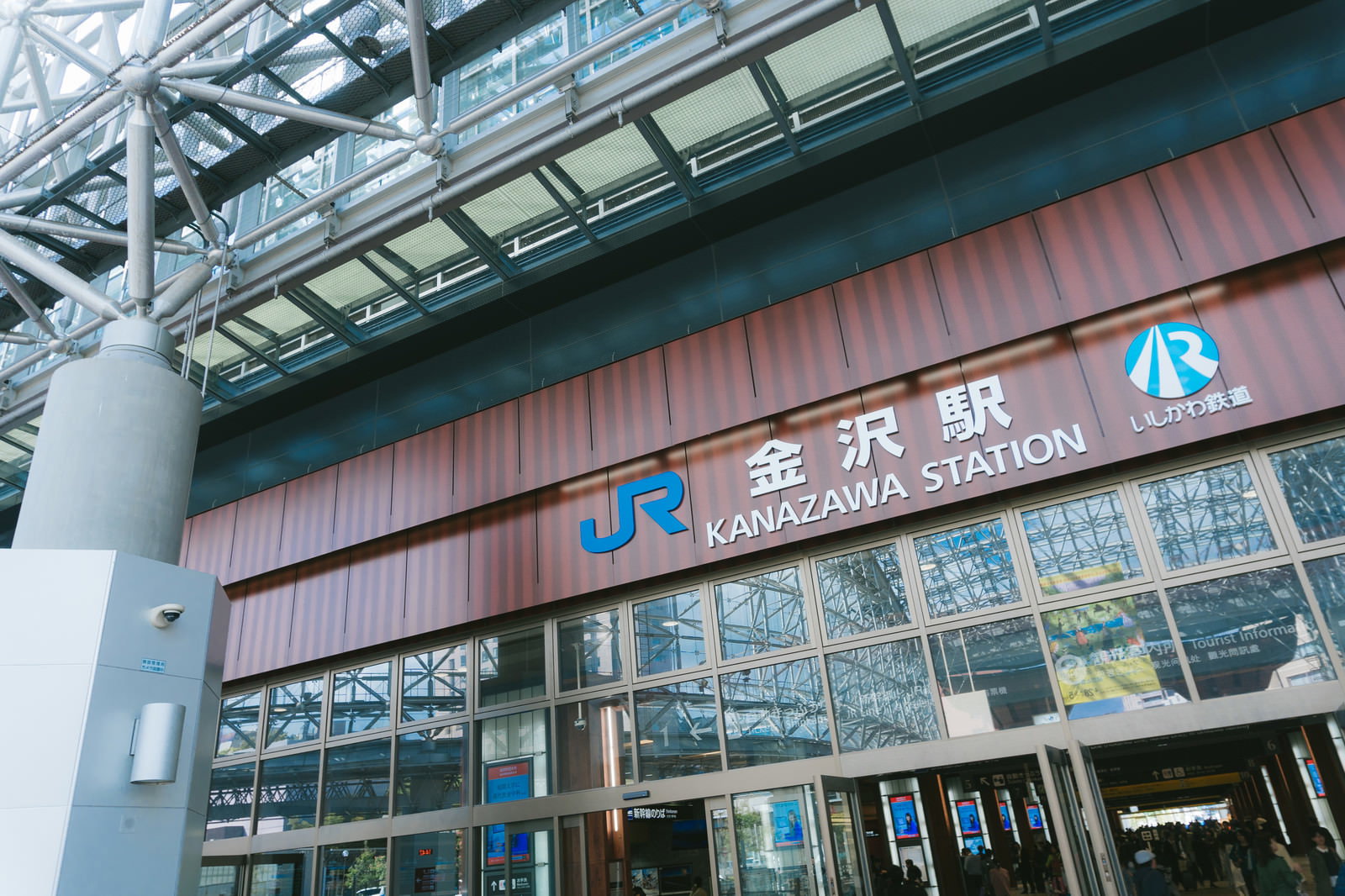 JR金沢駅の駅舎。茶色いパネルと白いJRロゴが見える駅前風景