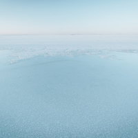 雲の隙間から光が差し込む海と山の風景の写真