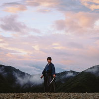 夕暮れの山中で二刀を構える侍の勇姿と雲霧の景観の写真