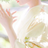 庭園を背景にした女性の和装ポートレートの写真