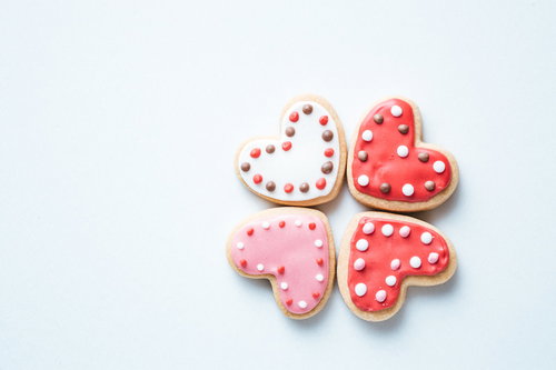 向き合う白とピンク、赤のハートのアイシングクッキー