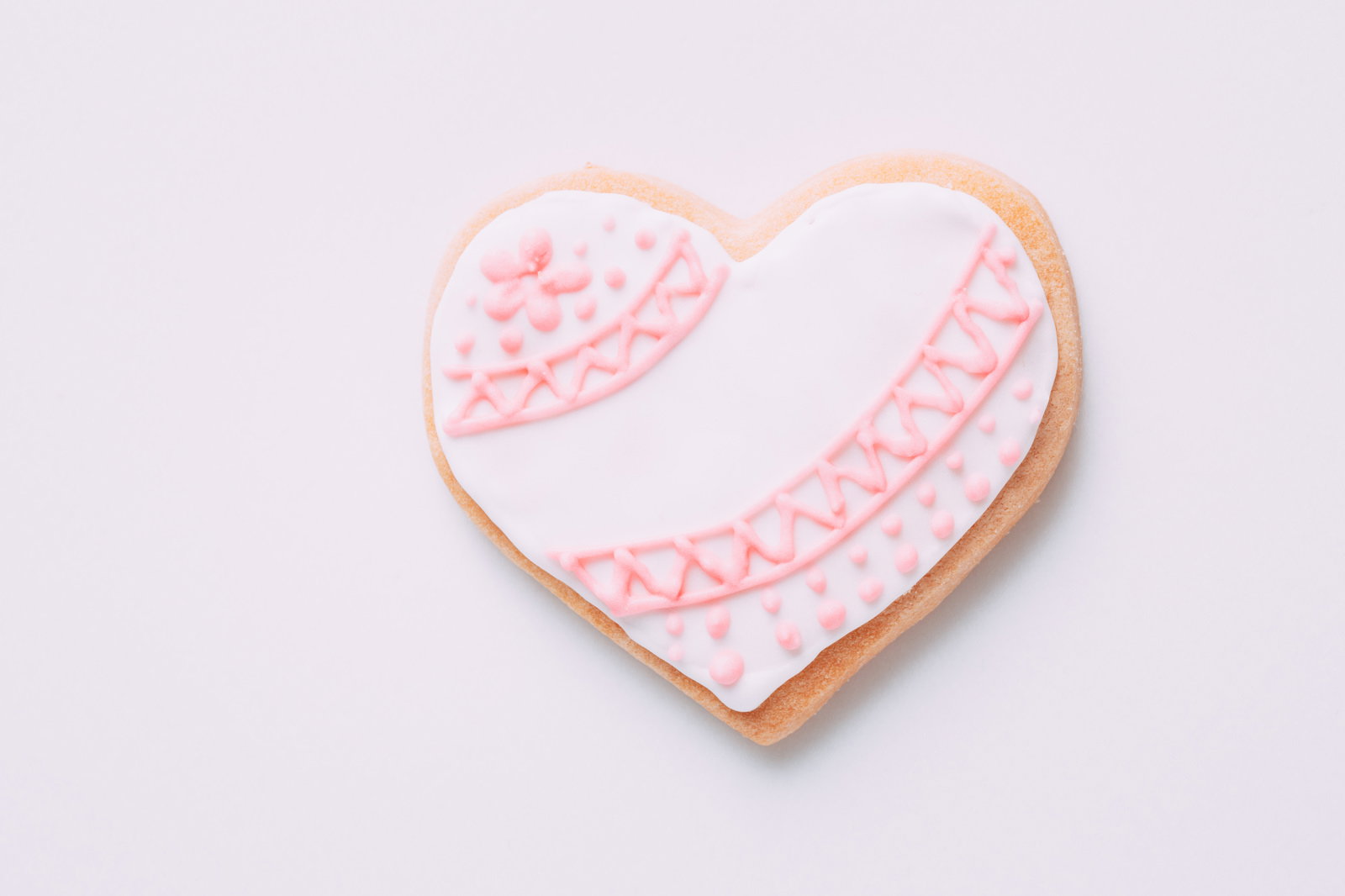 ピンク色の装飾が施されたハート型のアイシングクッキー