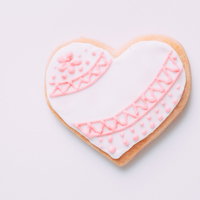 ピンク色の模様が描かれたハート型のアイシングクッキーの写真