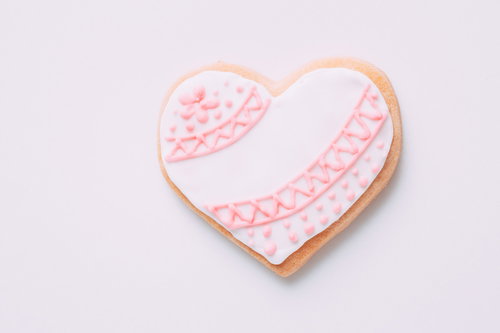 ピンク色の模様が描かれたハート型のアイシングクッキー