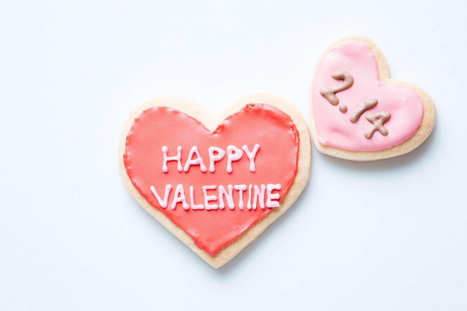 ピンクのアイシングでHAPPY VALENTINEと書かれたハート型クッキー
