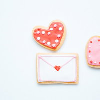 ラブレターを添えたハート型アイシングクッキーの写真