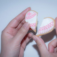 ピンクのアイシングが施された真っ二つに割られたハート型クッキーの写真
