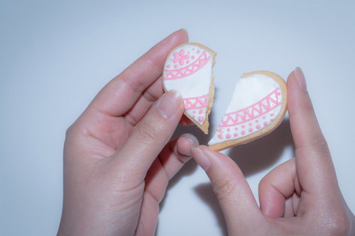 ピンクのアイシングが施された真っ二つに割られたハート型クッキー