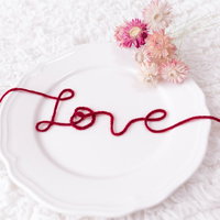 白い皿の上に赤い糸で紡ぐLOVE愛の告白の写真