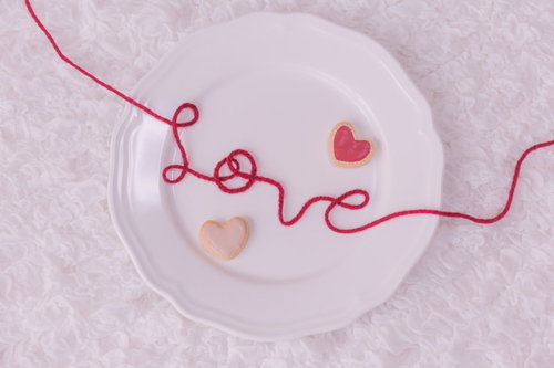白い丸皿の上に赤い糸で描かれたLOVEとハート