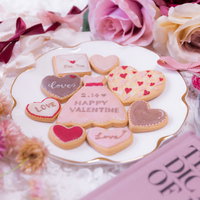 ピンク一色に囲まれたバレンタイン用のLOVEクッキーの写真