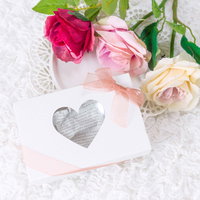 ハートのカードに添えたバラの花と告白のプレゼントの写真