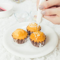 ホワイトチョコをデコり中の手作りカップケーキの写真