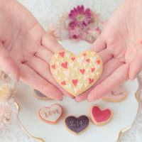 愛を込めた手作りハートクッキーをそっと包み込む両手の写真