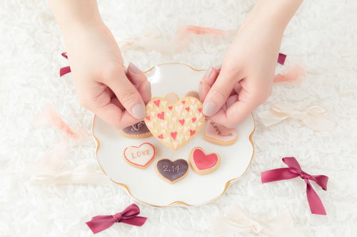 両手でつまんだハート型の手作りクッキー、バレンタインギフト